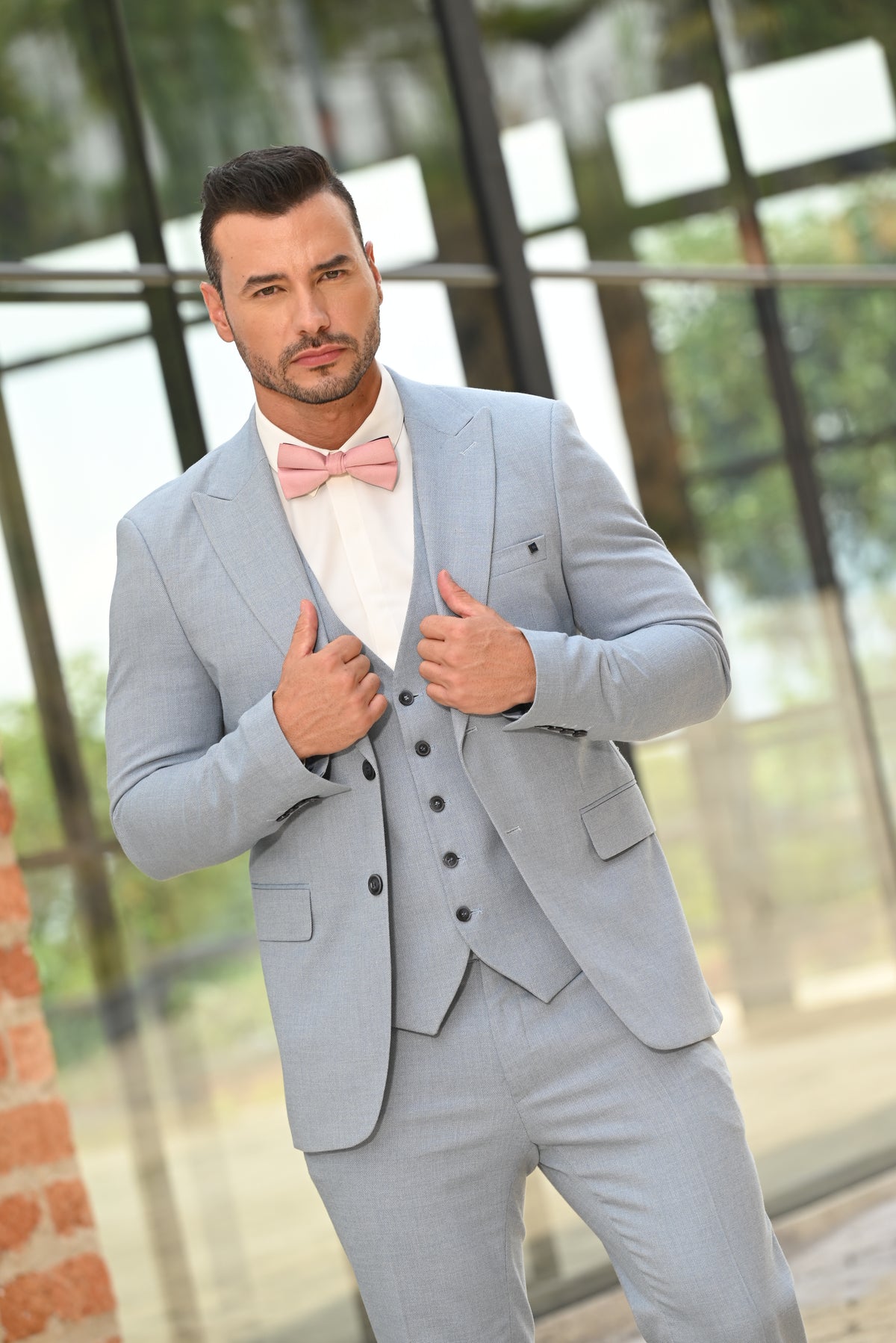 Modelo con traje de tres piezas azul claro, camisa blanca y corbatín rosado, alquiler de trajes para hombre en Medellín